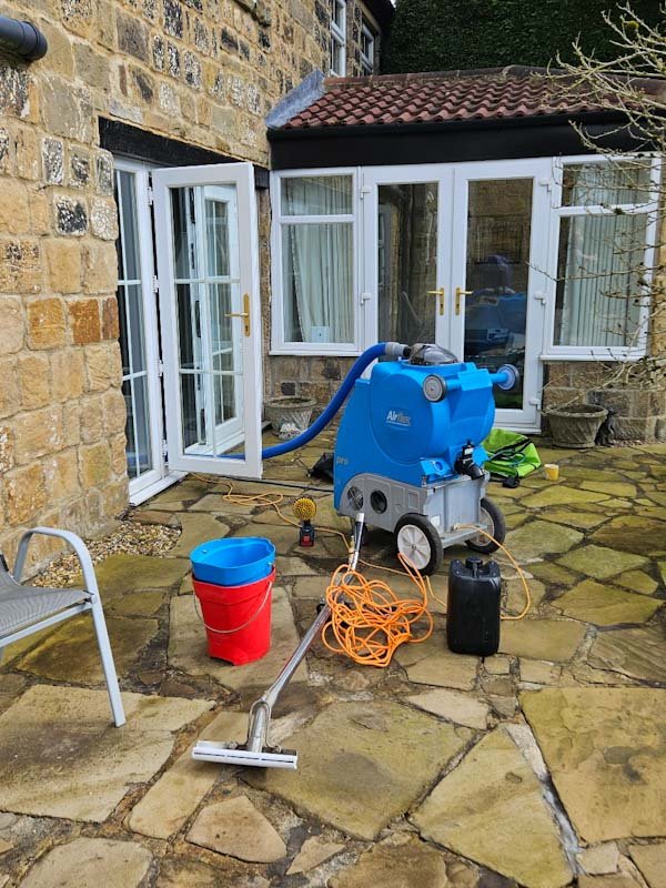 Professional carpet cleaning equipment set up outside a home in Wakefield