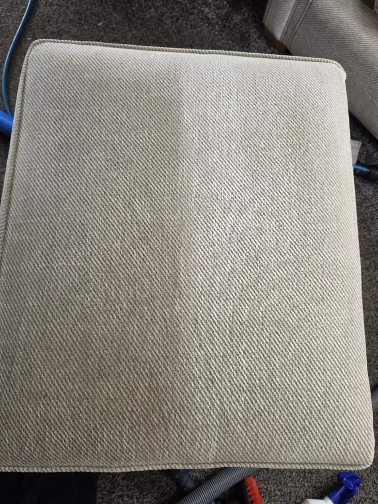 A detailed view of New Life Carpet cleaning a fabric seat cushion