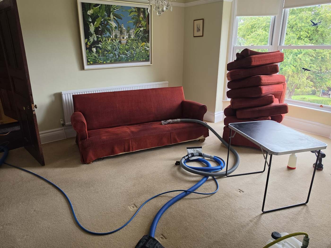 Upholstery Cleaning Leeds | Sofa & Chair Cleaning 1 Red fabric sofa and cushions with upholstery cleaning equipment during a New Life Carpet appointment