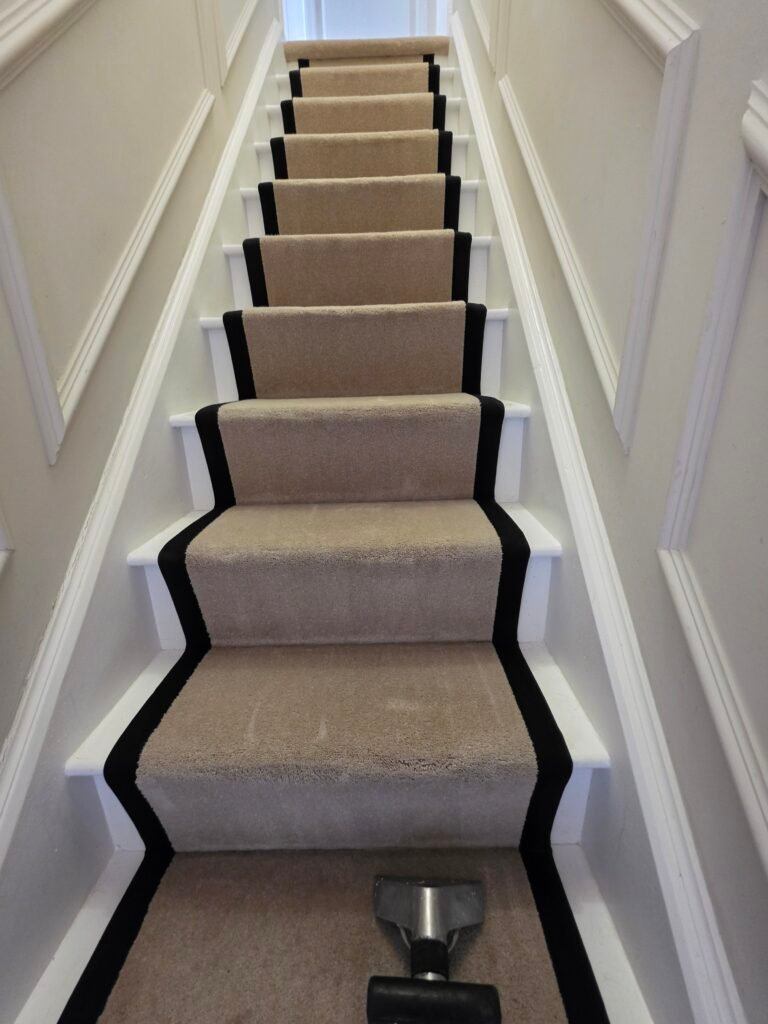 Beige stair runner with black edging from New Life Carpet’s work portfolio