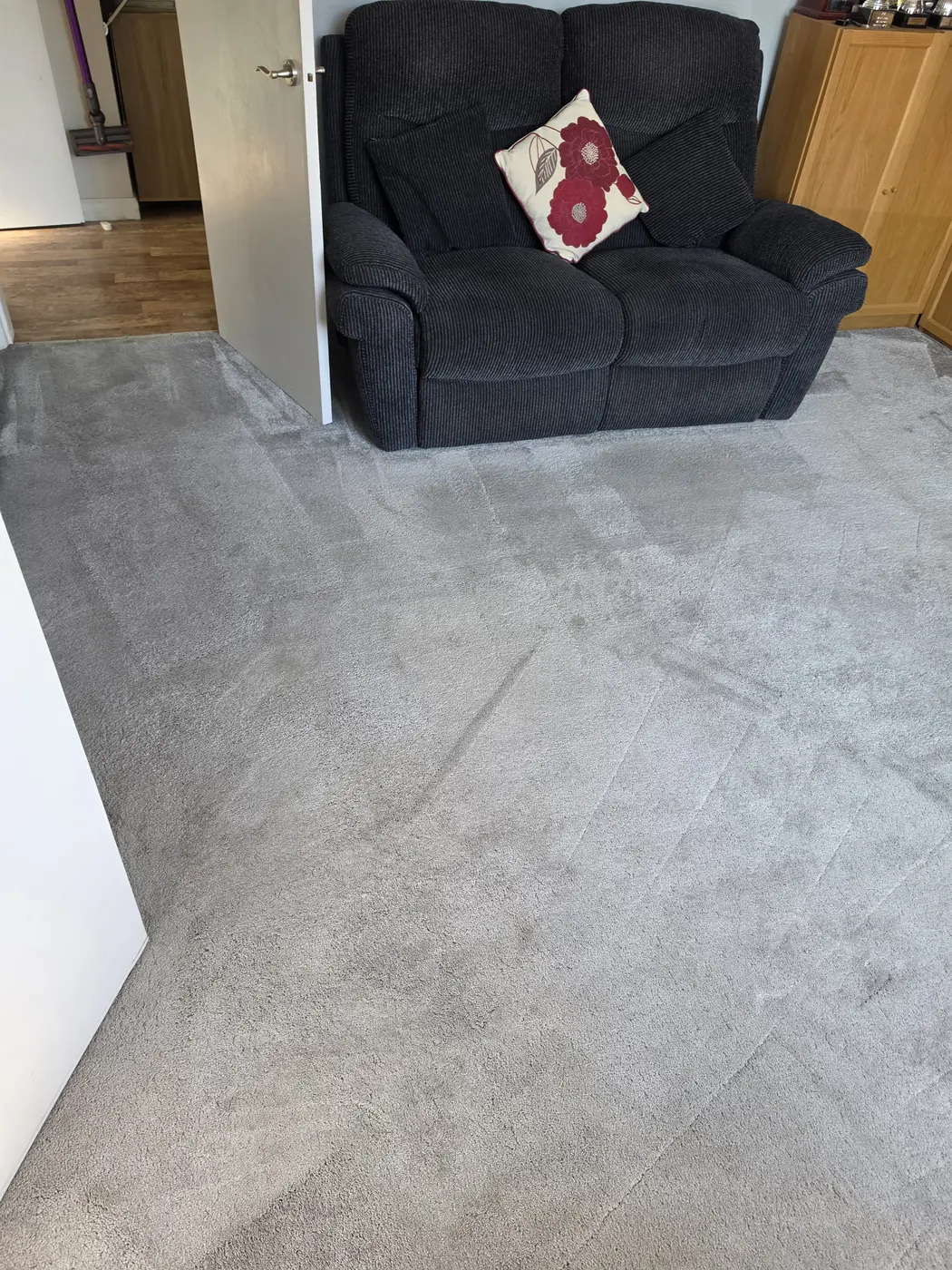 Light grey living-room carpet with dark fabric seating