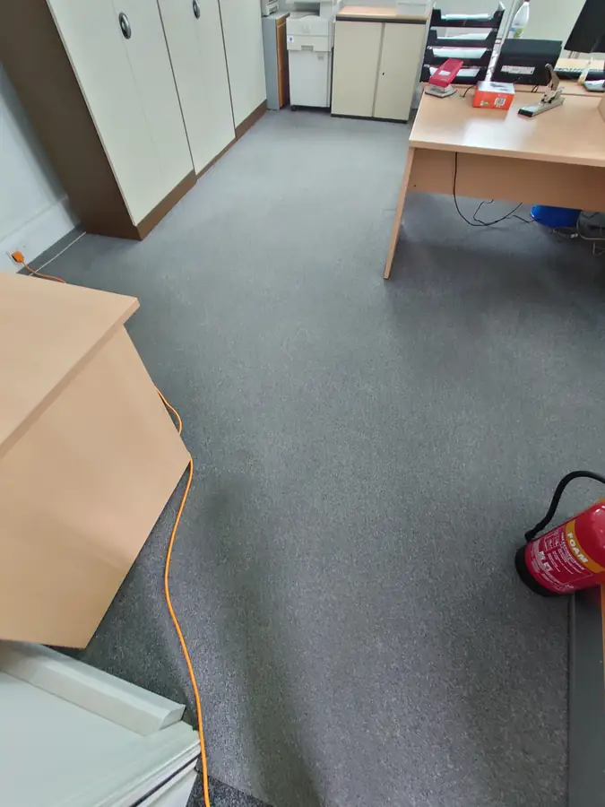 The same office carpet around the desk after cleaning